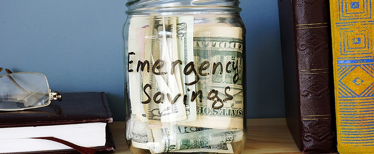 Jar on bookshelf with emergency savings cash