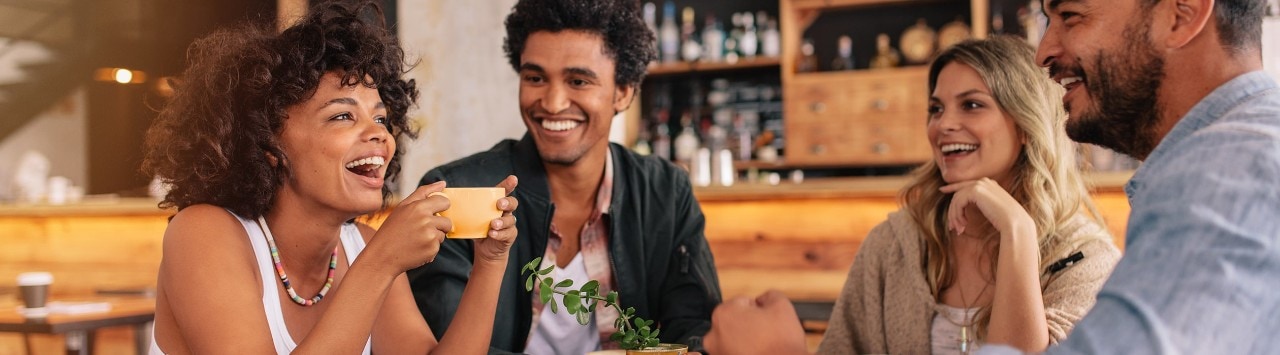 Diverse group of friends sitting at table in coffee bar