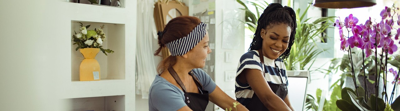 Two female flower shop owners arranging bouquets 