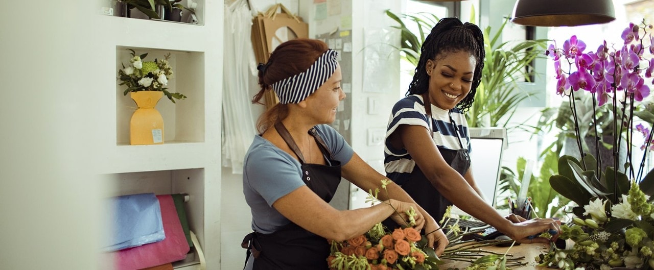 Two female flower shop owners arranging bouquets 