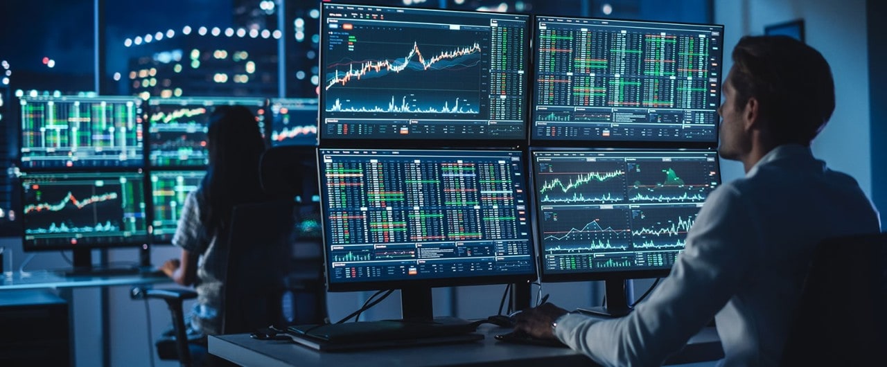 Financial analysts reviewing stock data on multiple monitors