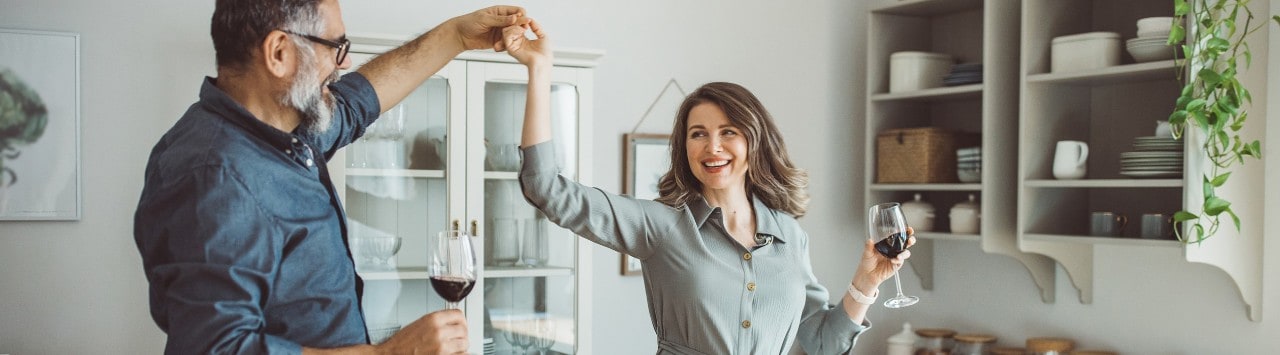 A retired couple dance together in the kitchen after finalizing their estate planning documents