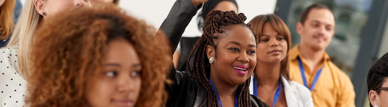 African-American woman raising her hand during a conference