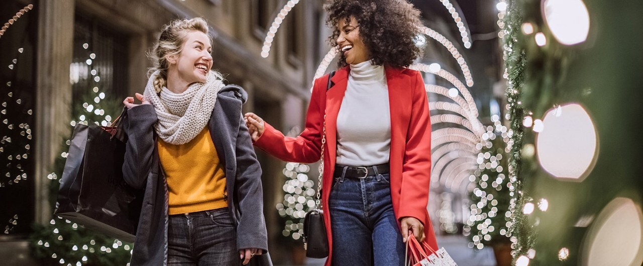 Happy Caucasian and African-American women shopping during the holidays