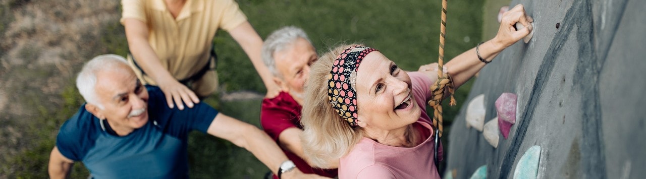 Retired people enjoying climbing a rock wall after applying for Social Security benefits