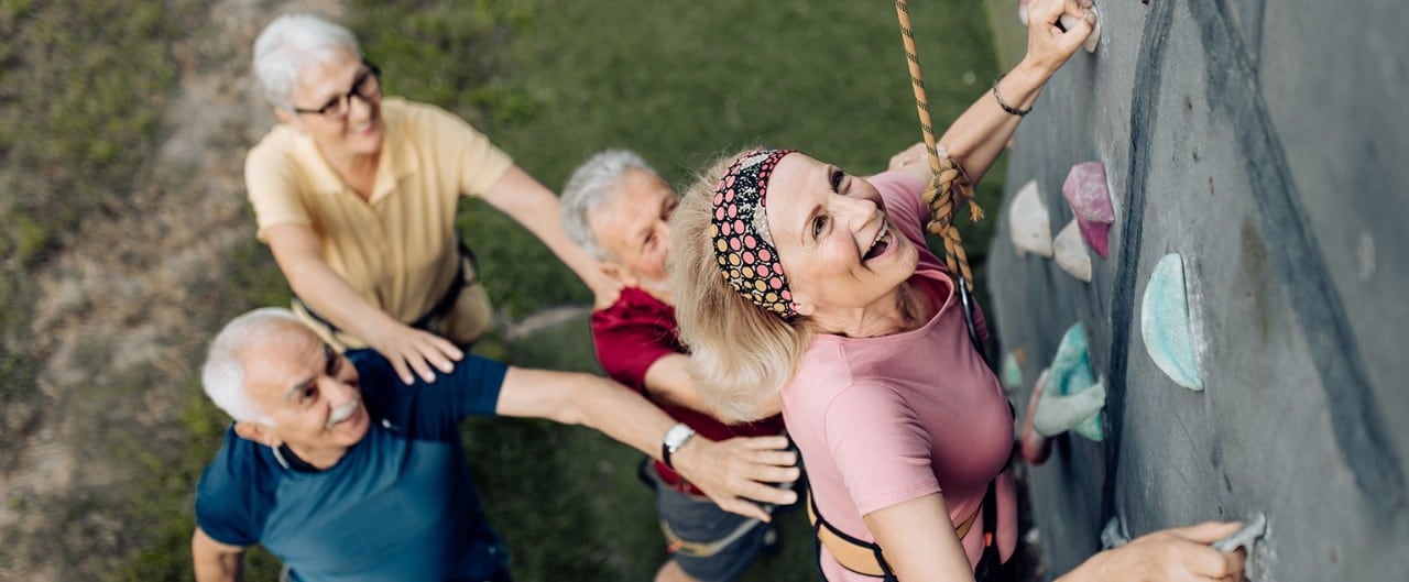 Retired people enjoying climbing a rock wall after applying for Social Security benefits