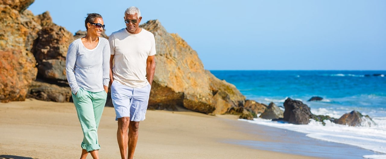 Mature couple walking along beach