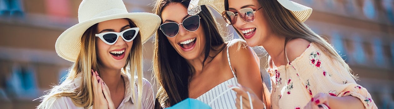 Three fashionable women looking at their purchases