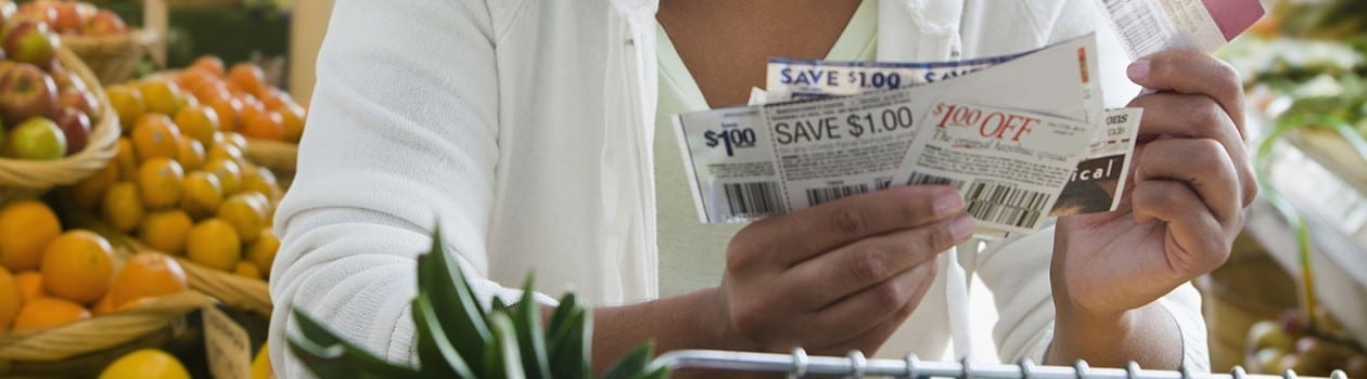 Frugal grocery shopper holding multiple coupons