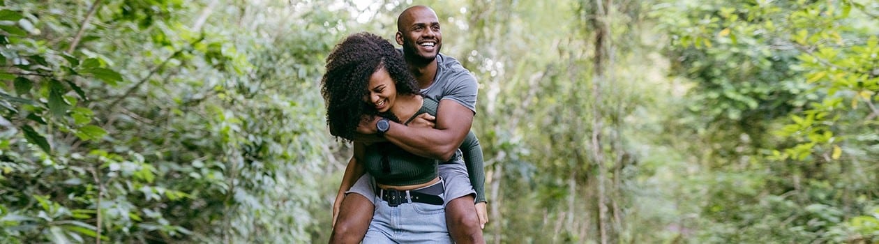 Young woman giving boyfriend a piggyback ride