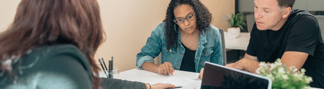 A couple reviews the portfolio construction of their investments with a financial planner as part of their wealth goal-setting process