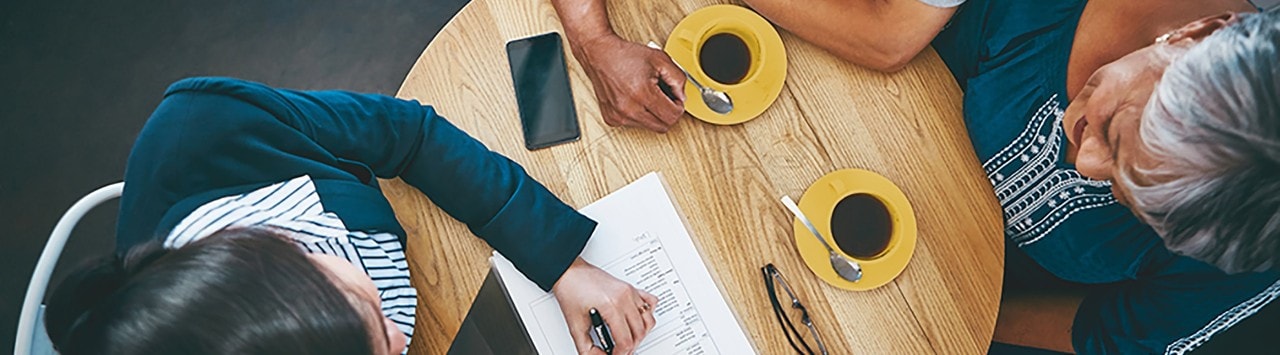 Couple sitting at small round table with advisor