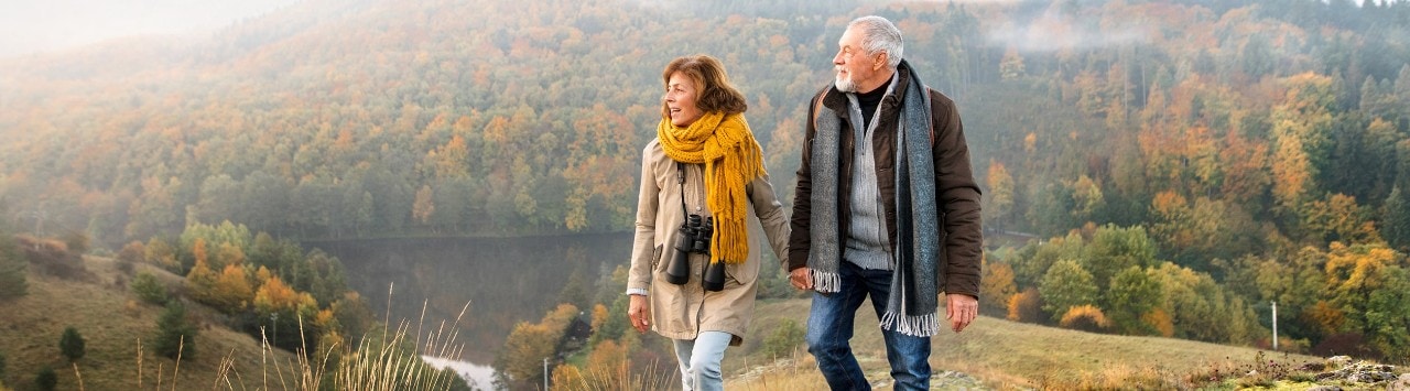 Senior couple hiking in hills overlooking river