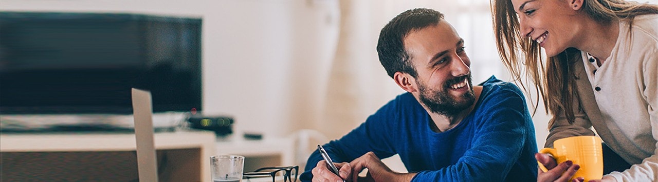 Couple at desk with laptop reviewing financial documents