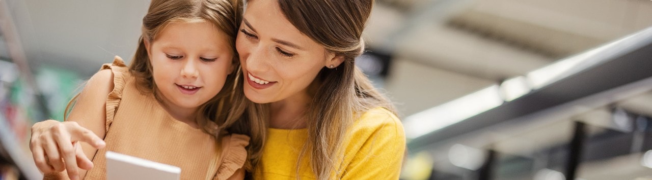Mother and daughter in grocery store looking at shopping list