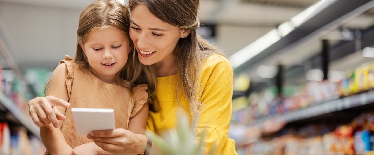 Mother and daughter in grocery store looking at shopping list