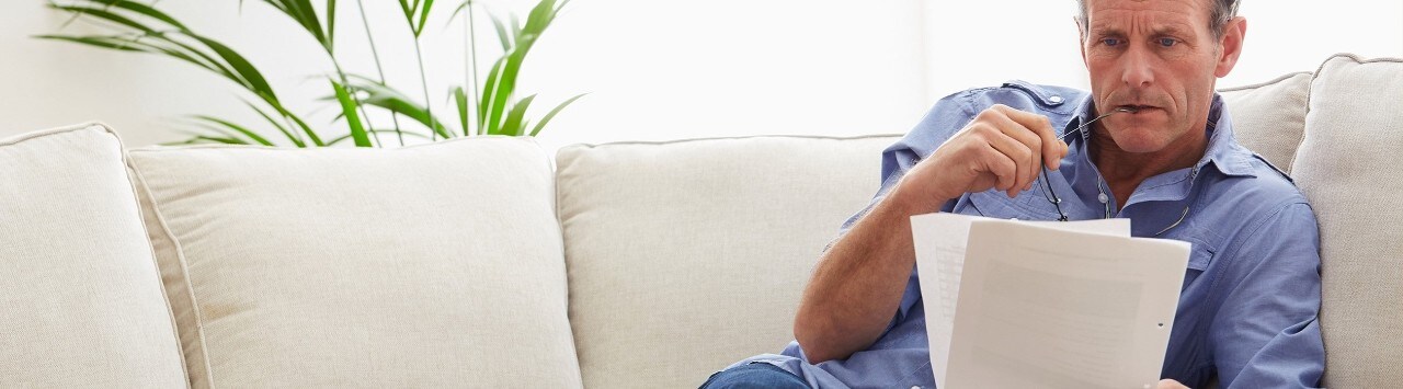 Middle-aged man reviewing documents on sofa