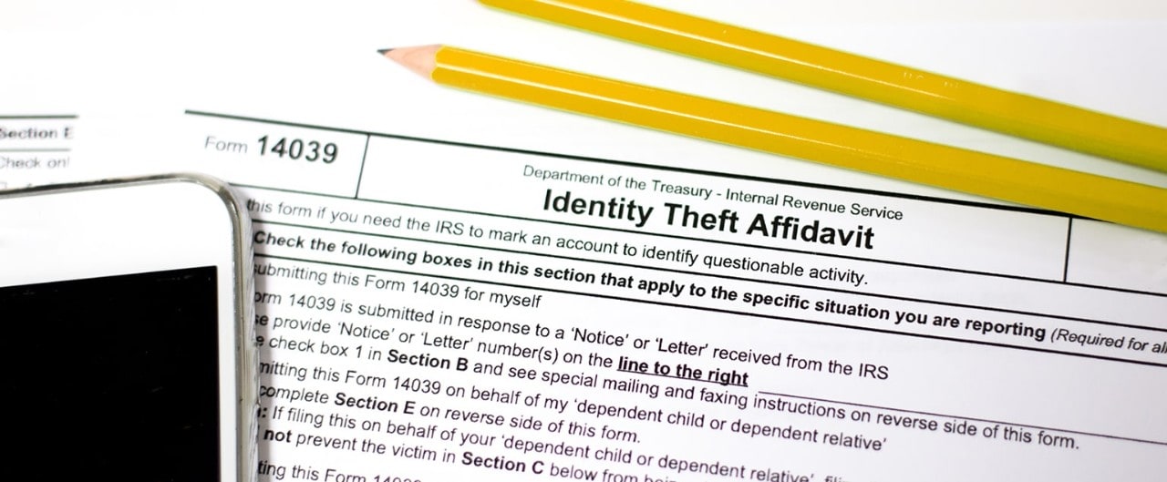 Smartphone and pencils on top of Identity Theft Affidavit form