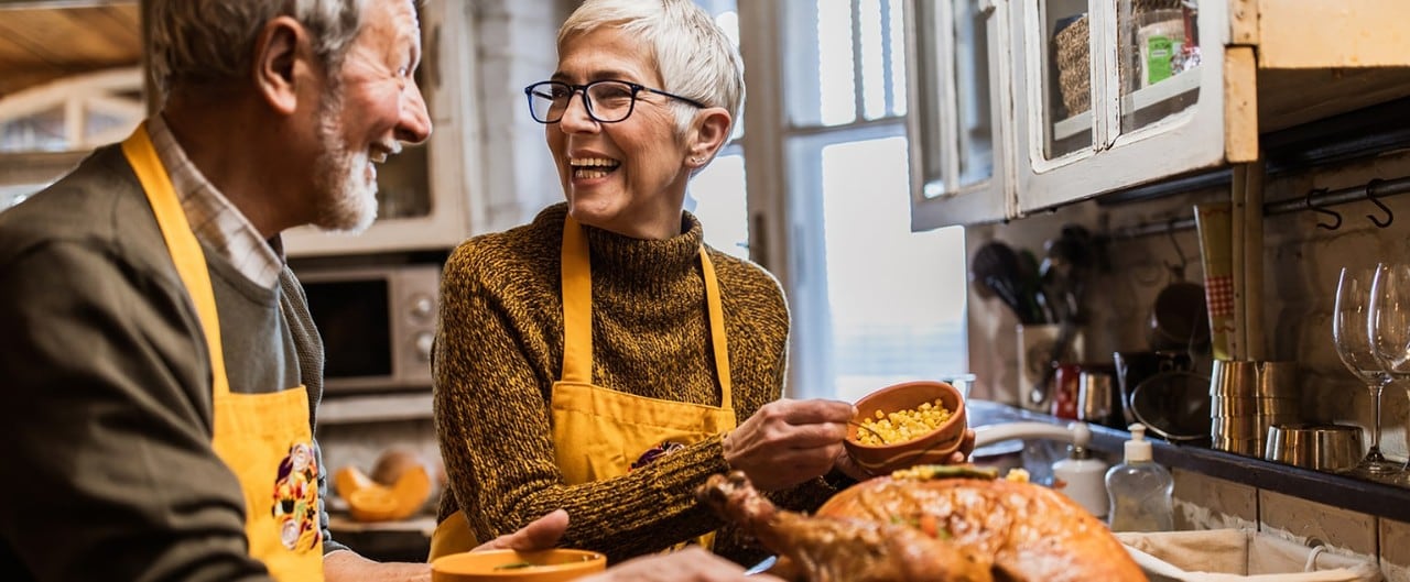 Older Caucasian couple preparing Thanksgiving dinner