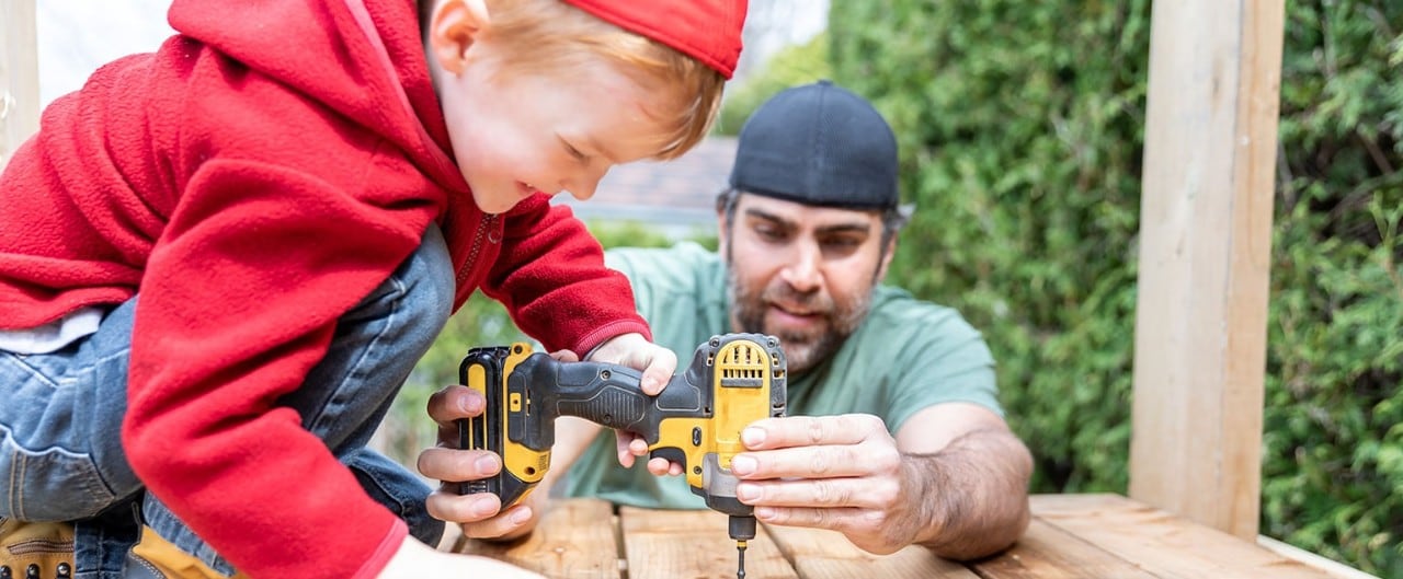 Man and child operating power tools