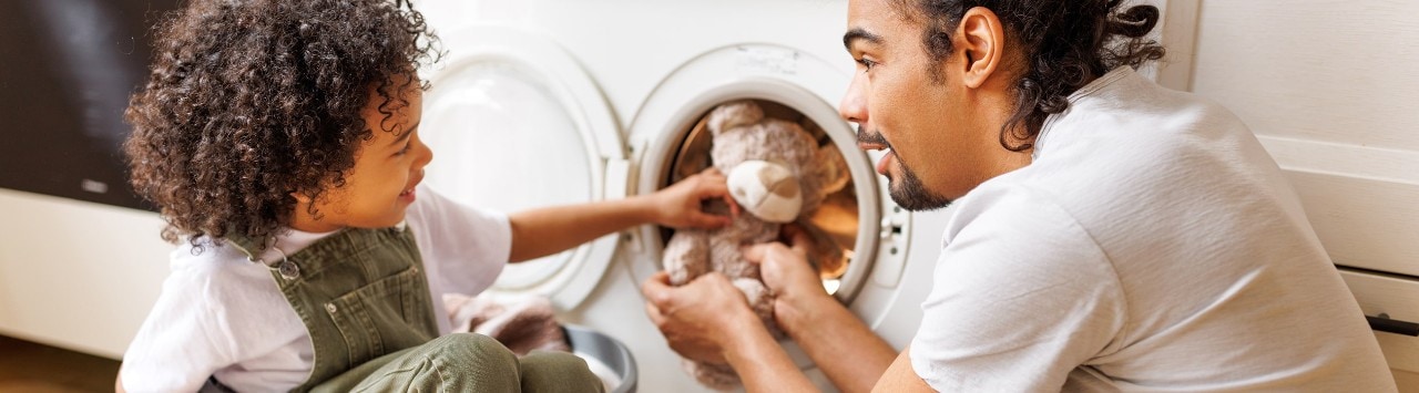 Father and young child doing laundry