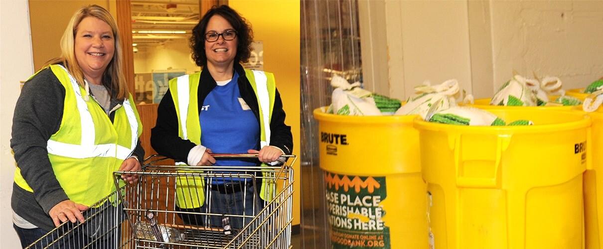 Two volunteers with shopping cart and buckets of donations at food bank