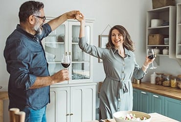 A retired couple dance together in the kitchen after finalizing their estate planning documents