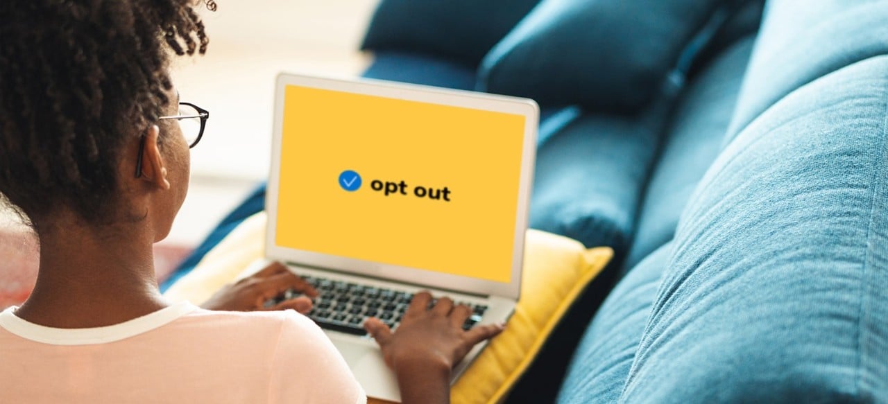 African-American woman on couch  using laptop with opt out on screen